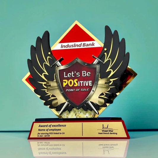 Recognition award with a shield, two swords, and wings. 'Let's be POSitive' written on the shield.